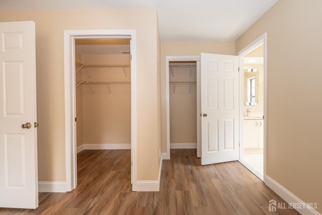 2708 Ridgefield Ct, Helmetta, NJ 08828 - unfurnished bedroom featuring wood finished floors, baseboards, and two closets