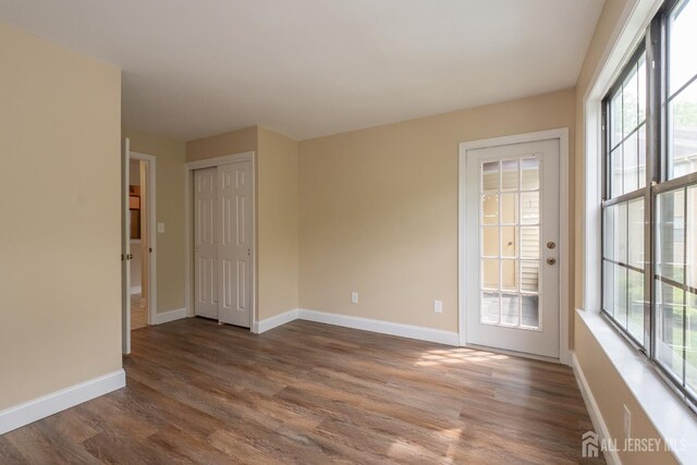 2708 Ridgefield Ct, Helmetta, NJ 08828 - unfurnished room featuring plenty of natural light, dark wood-type flooring, and baseboards