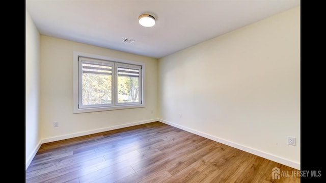 spare room with hardwood / wood-style floors