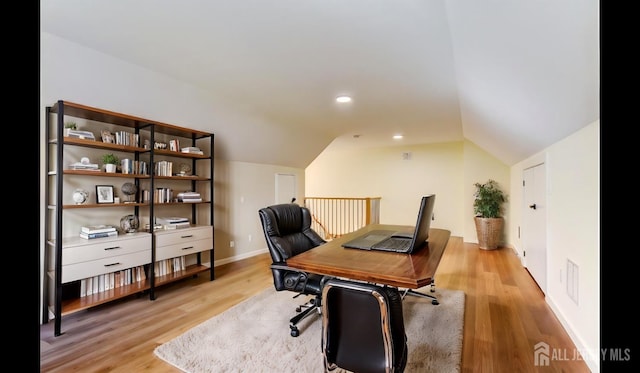 home office with lofted ceiling and light hardwood / wood-style floors