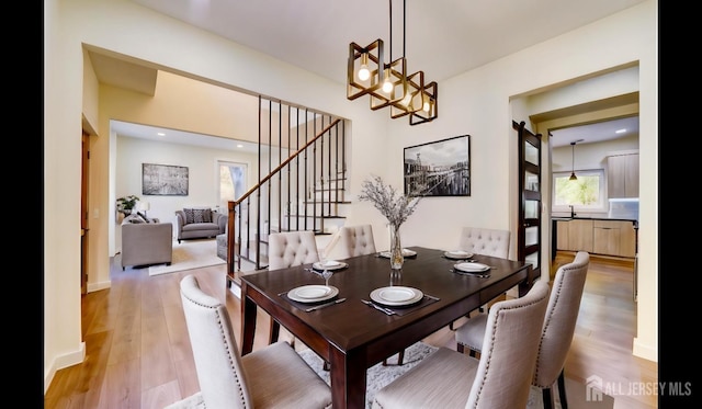 dining area with an inviting chandelier and light hardwood / wood-style flooring