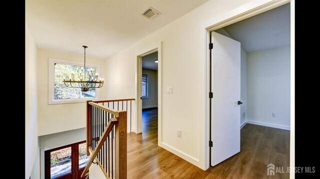 hallway featuring a chandelier and hardwood / wood-style floors