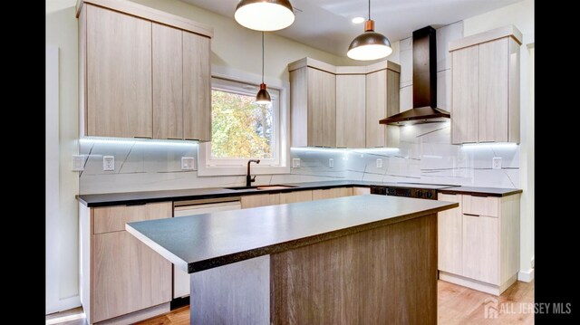 kitchen with a center island, sink, wall chimney range hood, light hardwood / wood-style floors, and light brown cabinetry