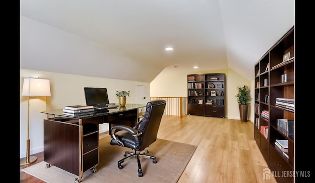 office featuring lofted ceiling and light hardwood / wood-style floors