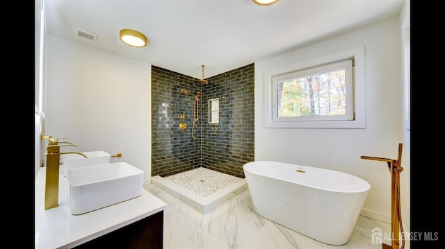 bathroom with vanity and shower with separate bathtub