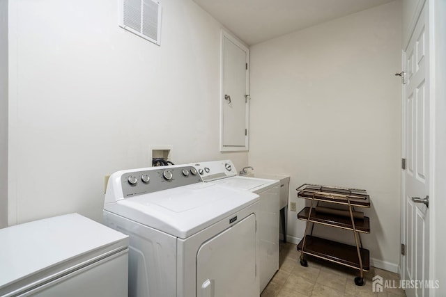 laundry room with washing machine and clothes dryer, visible vents, cabinet space, and baseboards