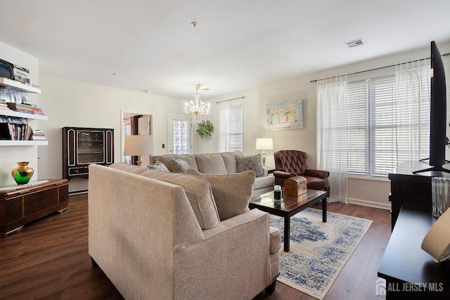 living room featuring a notable chandelier, baseboards, visible vents, and dark wood-style flooring