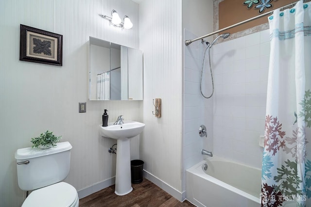 full bath featuring toilet, shower / tub combo with curtain, baseboards, and wood finished floors