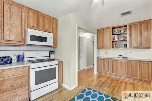 kitchen featuring white appliances, visible vents, light wood-style floors, light countertops, and open shelves