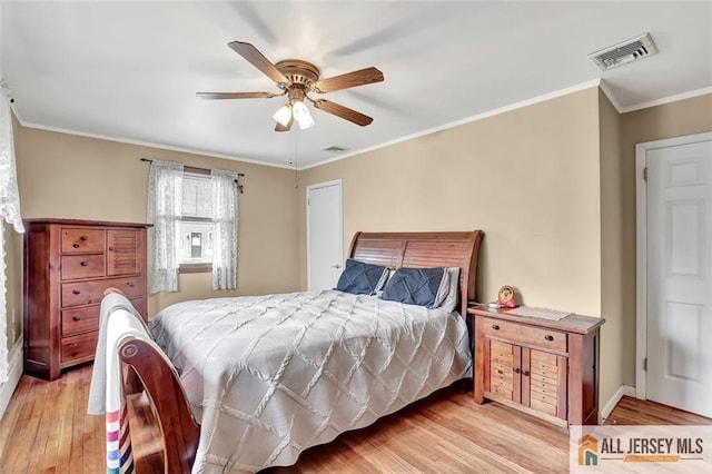 bedroom featuring baseboards, visible vents, a ceiling fan, light wood-style flooring, and ornamental molding