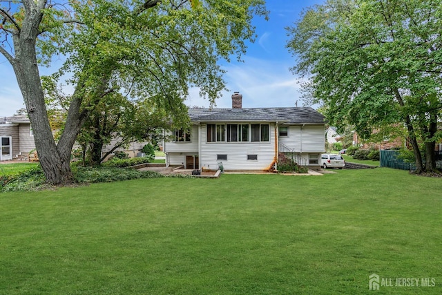 rear view of property with a yard