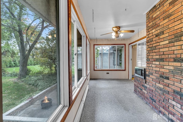 unfurnished sunroom with a wood stove