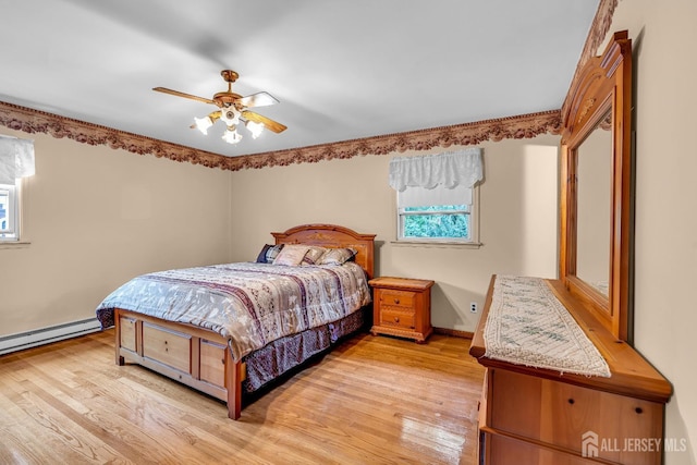 bedroom with ceiling fan, a baseboard heating unit, and light hardwood / wood-style flooring