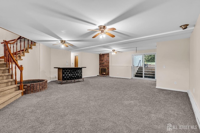 unfurnished living room with carpet flooring, ceiling fan, and a brick fireplace