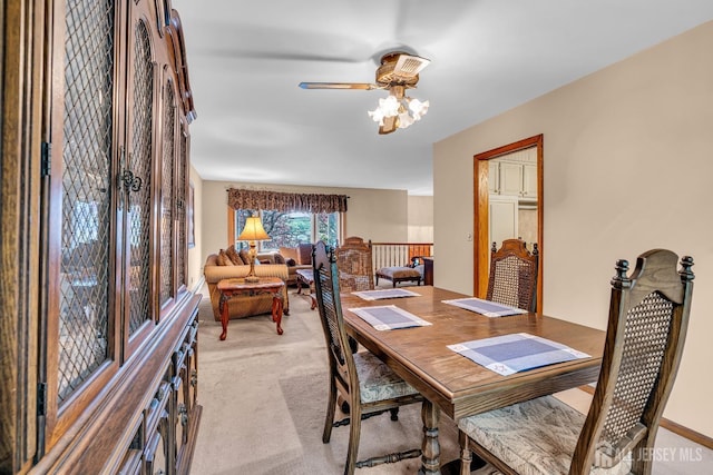 carpeted dining room with ceiling fan