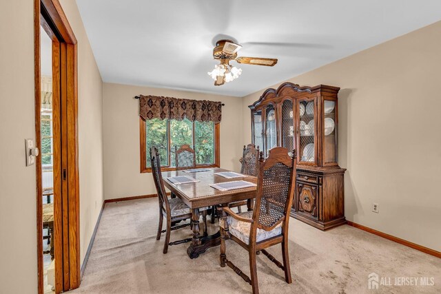 carpeted dining space with ceiling fan