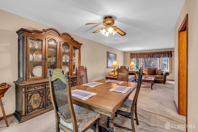 carpeted dining room with ceiling fan