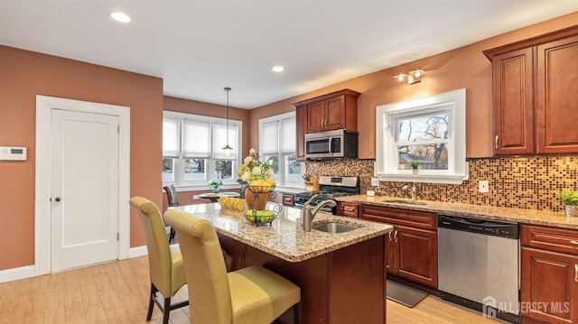 kitchen featuring a sink, light stone counters, and stainless steel appliances