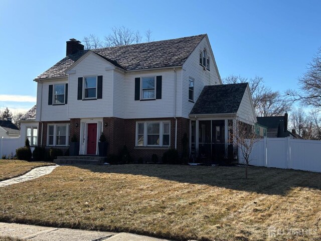 view of property featuring a front yard and a sunroom