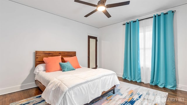 bedroom featuring baseboards, a ceiling fan, and wood finished floors