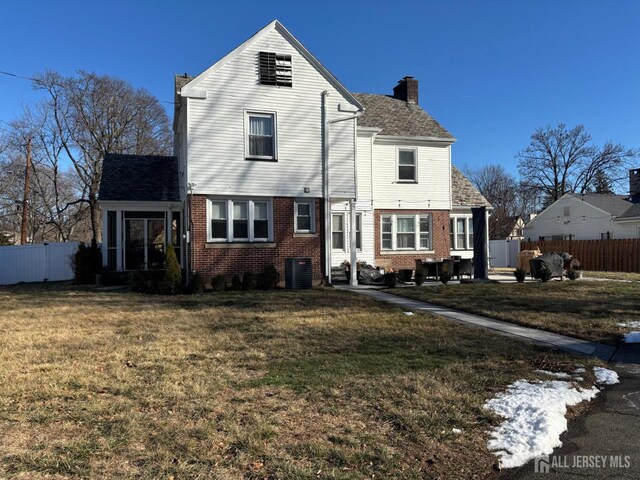 rear view of house with a lawn and central air condition unit