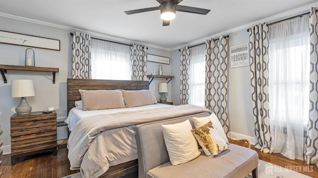 bedroom with multiple windows, wood finished floors, and ornamental molding