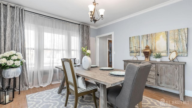 dining room featuring a notable chandelier, crown molding, and wood finished floors