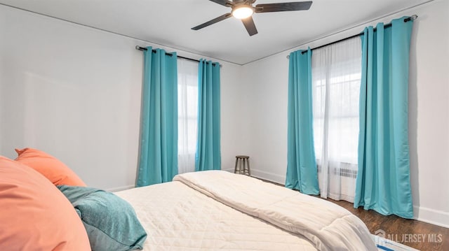 bedroom with baseboards, wood finished floors, and a ceiling fan
