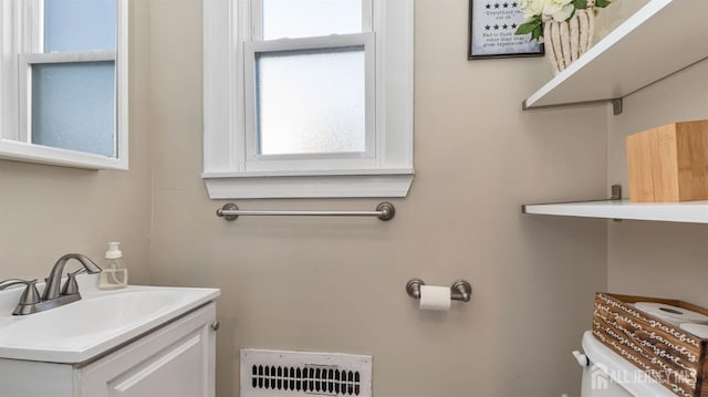 half bathroom with toilet and vanity