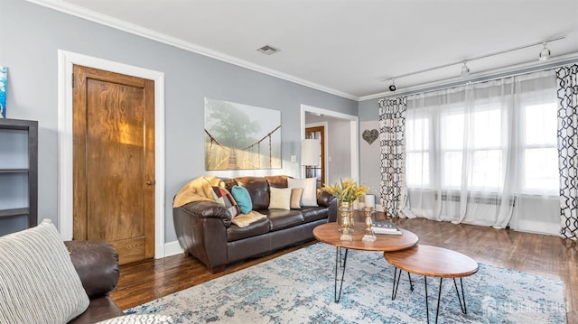 living area with visible vents, wood finished floors, ornamental molding, and track lighting