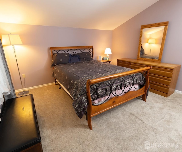 bedroom with carpet floors, vaulted ceiling, and baseboards