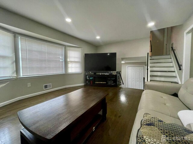 living room with vaulted ceiling and dark wood-type flooring