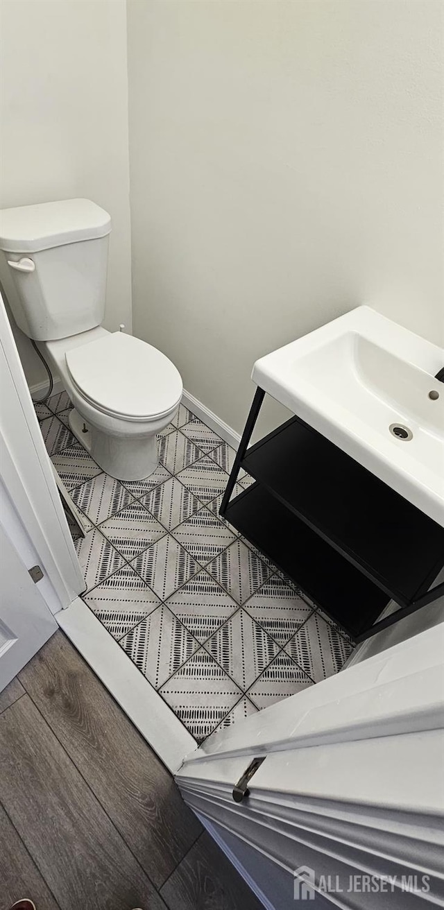 bathroom featuring vanity, wood-type flooring, and toilet