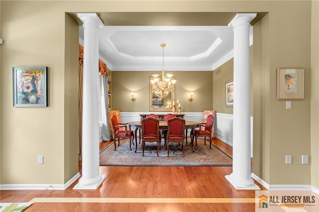 8 Tamarack Rd, Monroe, NJ 08831 - dining area with decorative columns, wood finished floors, a raised ceiling, crown molding, and a wainscoted wall