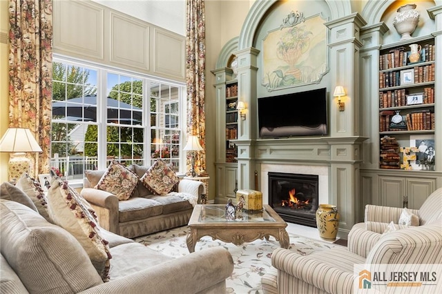 8 Tamarack Rd, Monroe, NJ 08831 - living room featuring built in features, a glass covered fireplace, and a towering ceiling