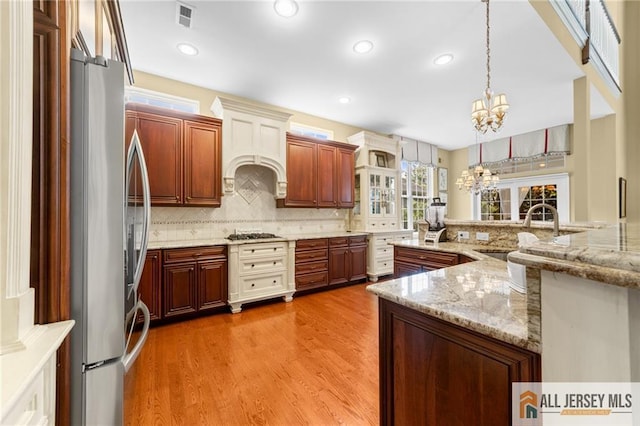 8 Tamarack Rd, Monroe, NJ 08831 - kitchen featuring appliances with stainless steel finishes, a chandelier, decorative backsplash, decorative light fixtures, and light wood finished floors