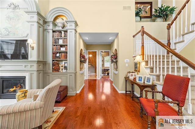 8 Tamarack Rd, Monroe, NJ 08831 - hallway featuring stairs, wood finished floors, built in shelves, a high ceiling, and ornate columns
