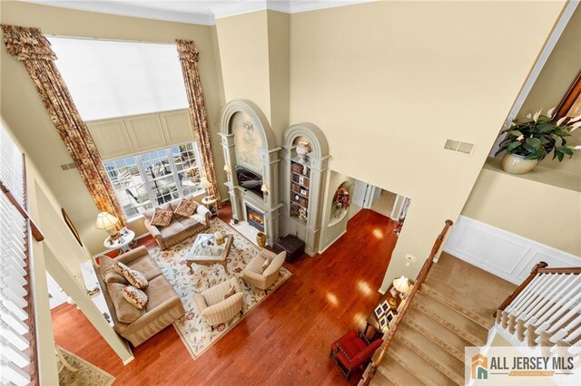 8 Tamarack Rd, Monroe, NJ 08831 - living area with ornamental molding, wood finished floors, plenty of natural light, a high ceiling, and a lit fireplace