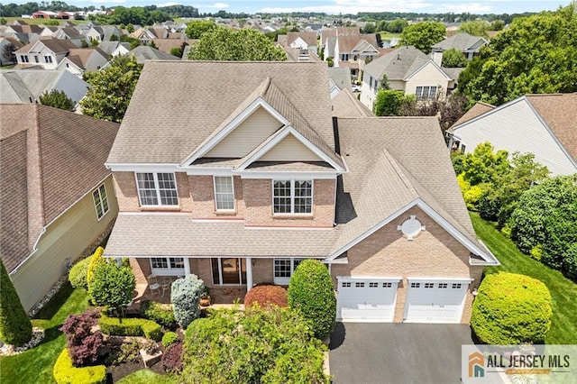 8 Tamarack Rd, Monroe, NJ 08831 - view of front facade with an attached garage, asphalt driveway, a residential view, brick siding, and roof with shingles