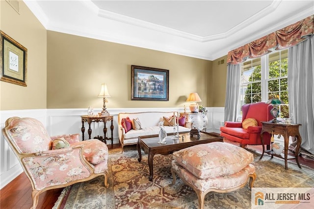 8 Tamarack Rd, Monroe, NJ 08831 - living room featuring a tray ceiling, wood finished floors, crown molding, a decorative wall, and wainscoting