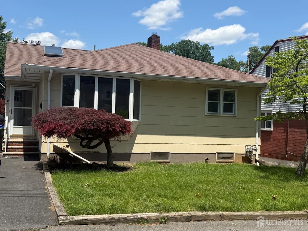 119 Burnett St, Edison, NJ 08817 - view of home's exterior with a lawn, roof with shingles, entry steps, and a chimney