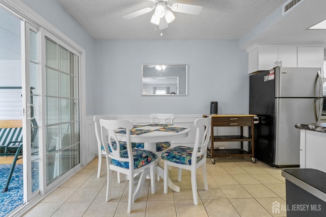 211 Rossmoor Dr Unit B, Monroe, NJ 08831 - dining space with a textured ceiling, wainscoting, light tile patterned floors, and a ceiling fan
