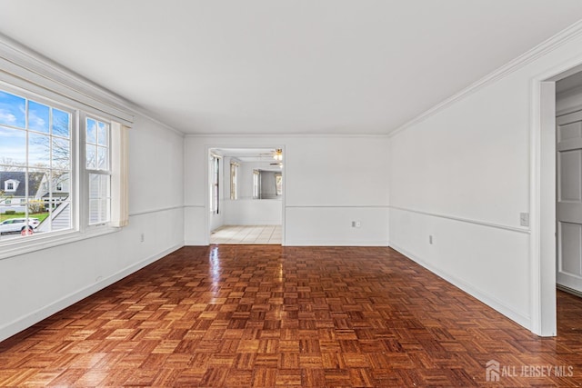 spare room featuring baseboards, ornamental molding, and ceiling fan