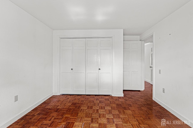 unfurnished bedroom with a closet and baseboards