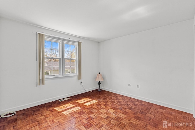 unfurnished room featuring visible vents and baseboards