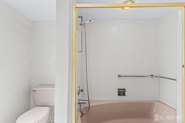 bathroom with bathing tub / shower combination and toilet