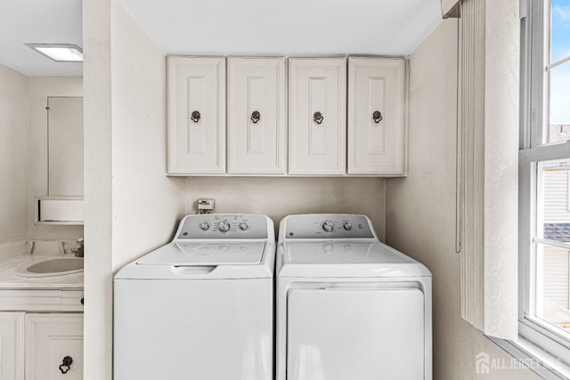 clothes washing area featuring separate washer and dryer and a sink