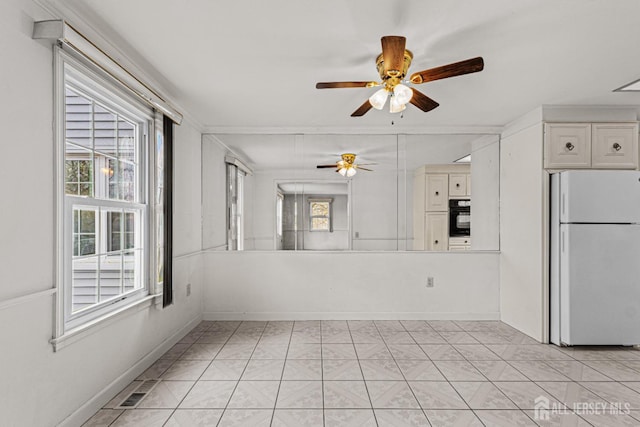 empty room with a ceiling fan, visible vents, and baseboards