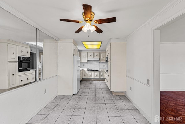 kitchen with freestanding refrigerator, gas cooktop, oven, ornamental molding, and a ceiling fan