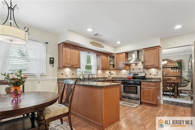 39 Evergreen Ter, Monroe, NJ 08831 - kitchen featuring wall chimney range hood, stainless steel gas stove, brown cabinets, a peninsula, and recessed lighting